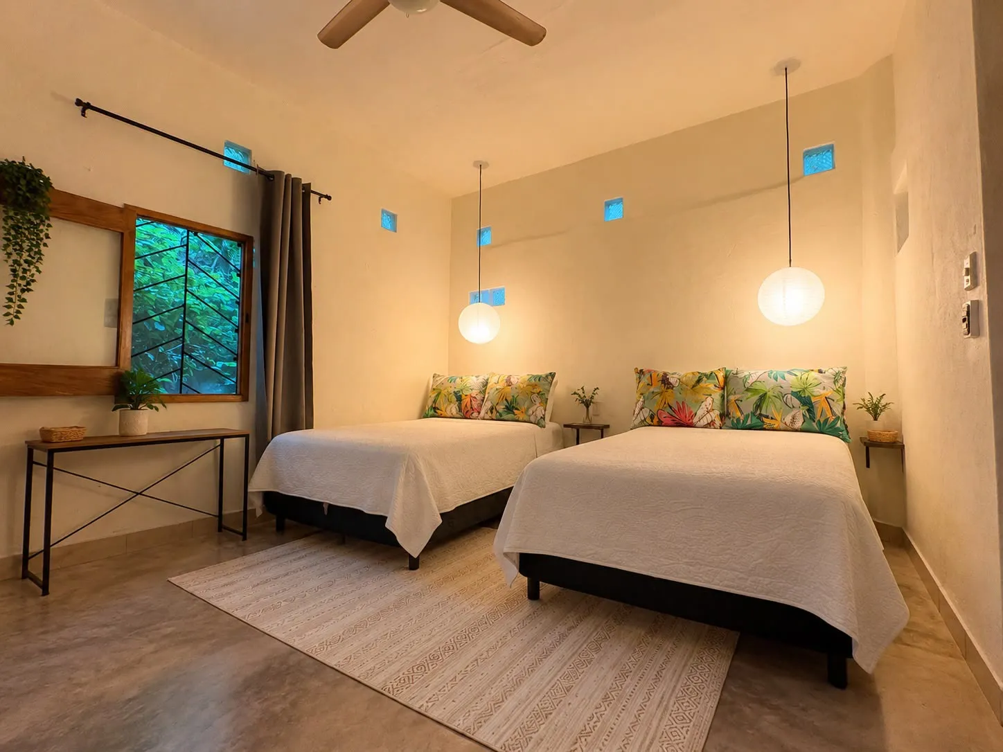Habitación con dos camas individuales y lámparas colgantes.